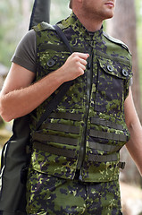 Image showing close up of soldier or hunter with gun in forest