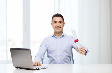 Image showing smiling man with diploma and laptop at office