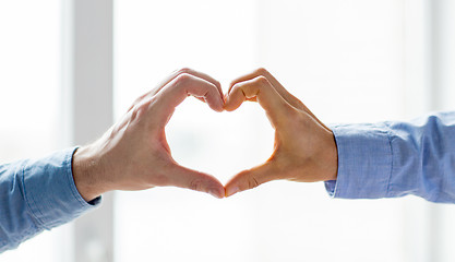 Image showing close up of male gay couple hands showing heart