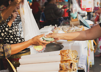 Image showing close up of hands giving money at street market