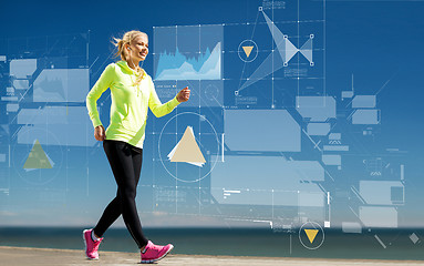 Image showing smiling young woman walking outdoors