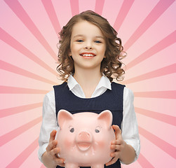 Image showing happy girl holding piggy bank