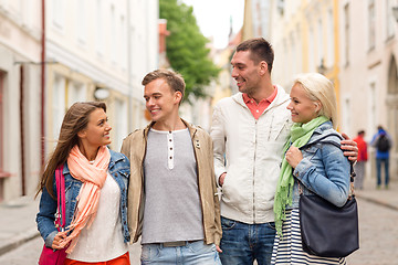 Image showing group of smiling friends walking in the city