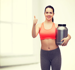 Image showing teenage girl with jar of protein showing thumbs up