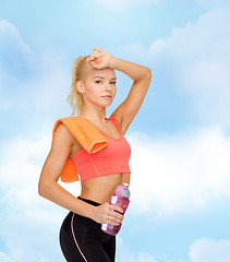 Image showing tired sporty woman with towel and water bottle