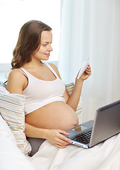 Image showing pregnant woman with laptop and ultrasound image