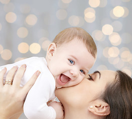 Image showing happy mother with baby over lights background