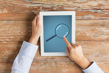 Image showing close up of male hands with magnifier on tablet pc