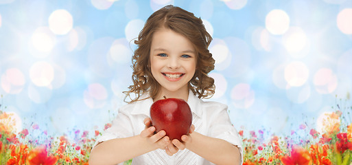 Image showing happy girl holding apple over garden background