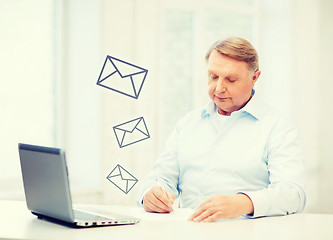 Image showing old man filling a form at home