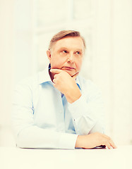 Image showing stressed old man holding head at home