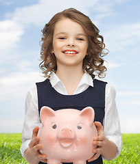 Image showing happy girl holding piggy bank