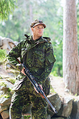 Image showing young soldier or hunter with gun in forest