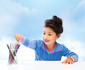 Image showing happy little girl drawing with coloring pencils