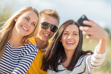 Image showing group of friends taking selfie with cell phone