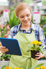 Image showing happy woman with tablet pc in greenhouse