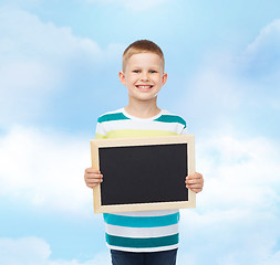Image showing smiling little boy holding blank black chalkboard
