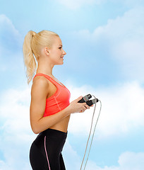Image showing smiling sporty woman with skipping rope
