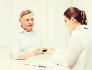 Image showing female doctor or nurse measuring blood sugar value