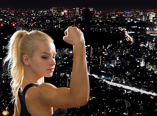 Image showing close up of athletic woman flexing her biceps