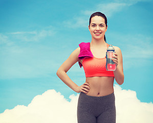 Image showing sporty woman with towel and water bottle