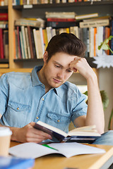Image showing male student reading book in library