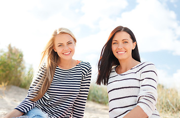 Image showing happy teenage girls or young women on beach