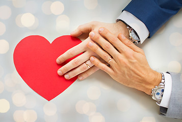 Image showing close up of male gay couple hands with red heart