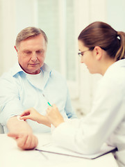 Image showing female doctor doing injection to old man