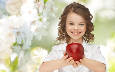 Image showing happy girl holding apple over garden background