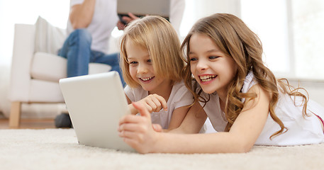 Image showing smiling sister with tablet pc and parents on back