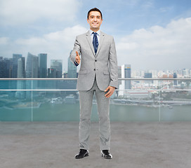 Image showing happy smiling businessman in suit shaking hand