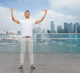 Image showing happy man with raised hands