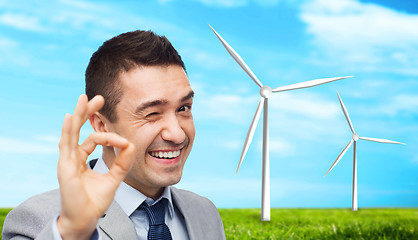 Image showing happy businessman in suit showing ok hand sign