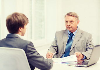 Image showing older man and young man having meeting in office