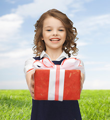 Image showing happy girl with red gift box over summer meadow