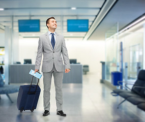 Image showing happy businessman in suit with travel bag