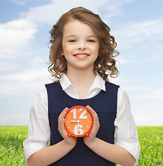 Image showing happy girl with alarm clock over summer background