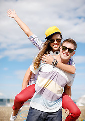 Image showing smiling teenagers in sunglasses having fun outside