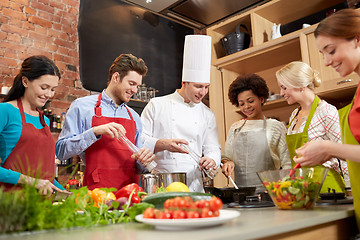 Image showing happy friends and chef cook cooking in kitchen