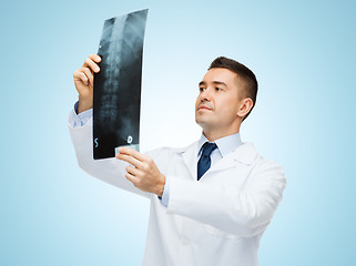 Image showing male doctor in white coat looking at x-ray