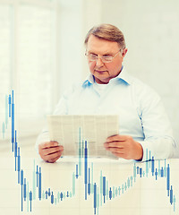 Image showing old man at home with newspaper and forex chart