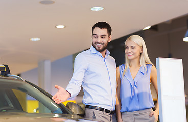 Image showing happy couple buying car in auto show or salon