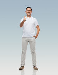 Image showing smiling man showing thumbs up over gray background