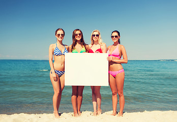 Image showing group of smiling women with blank board on beach