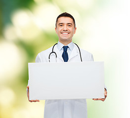 Image showing smiling male doctor holding white blank board