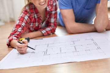 Image showing close up of couple with  blueprint at home