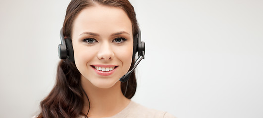 Image showing friendly female helpline operator with headphones