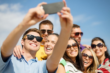 Image showing group of friends taking selfie with cell phone