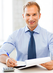 Image showing businessman with notebook and calculator